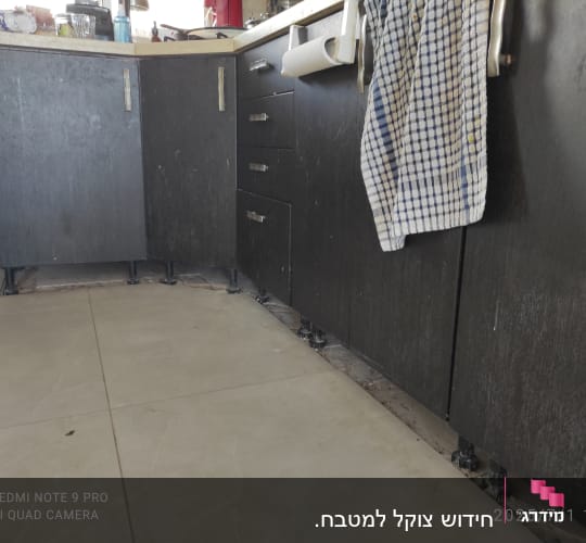 ארונות מטבח כהים עם מגבות תלויים